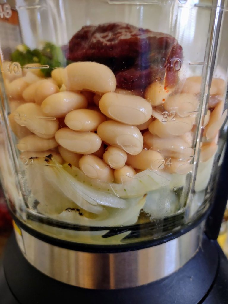 Blender filled with ingredients ready to be blended smooth to add to the chickpea chili

